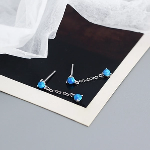 Macro view of silver s925 opal tassel earrings with delicate blue stone and chain details