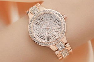 Détail de la montre en or rose avec pavage de diamants et cadran à chiffres romains