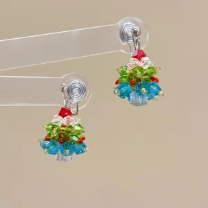 Detail of handcrafted beaded Christmas tree earrings with colorful crystal beads and spiral clip