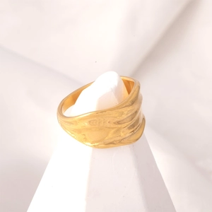 Detailed close-up showing the irregular wavy texture on a gold minimalist stainless steel ring