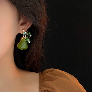 Elegant gold pear earrings with green crystals and blue gem shown on model