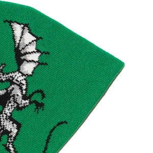 Close-up of green knitted fabric with a detailed white dragon jacquard pattern