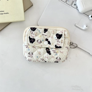 Quilted cream card wallet with black cat and dog prints on a modern desk setup