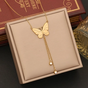 Elegant gold butterfly tassel necklace with long chains and crystal rhinestones on a box