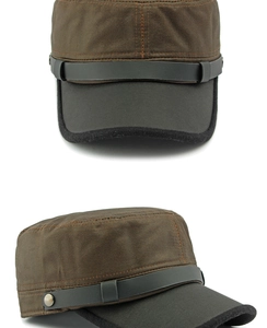 Detail of a dark brown military flat cap with black brim and studded leather strap
