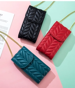 Close-up of three quilted leather phone bags in black, red and teal with gold chains