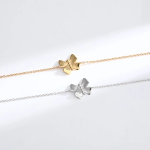 Detailed view of minimalist butterfly pendants in gold and silver finish with fine chains