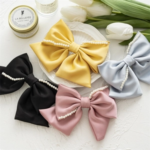 Flachbild von eleganten Satin-Bogen-Haarspangen mit Perlen in Gelb, Schwarz, Rosa und Blau