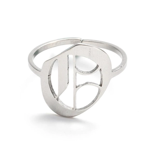 Detail of vintage silver stainless steel ring with ornate letter E hollow engraving