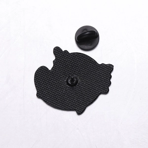 Detail of metal brooch back featuring honeycomb texture and black rubber pin clutch
