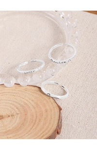 Macro shot of S925 sterling silver rings with Lucky and Smile engravings on wood