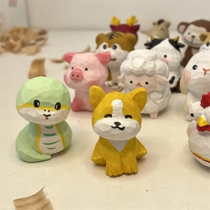Handcrafted miniature wooden zodiac animal figurines set on a white surface with wood chips