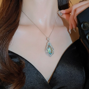 Detailed view of silver necklace with water drop blue gemstone and micro-pave crystals