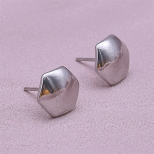Macro view of silver 304 stainless steel pentagonal stud earrings on pink fabric