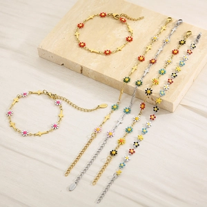 Detail of colorful enamel daisy and cross pendants on steel chains for jewelry