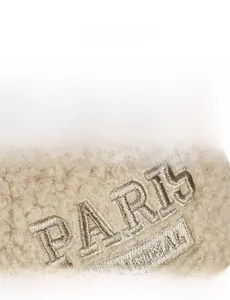 Close-up of beige fleece fabric texture with Paris Original embroidery on the cap