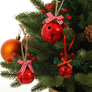 Christmas tree bells with red bows, berries and jute rope for festive home decoration