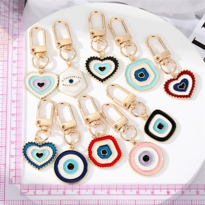 Detailed view of eleven colorful enamel evil eye charms on a white circular display stand