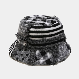 Detail of patchwork bucket hat featuring frayed edges and textured geometric patterns