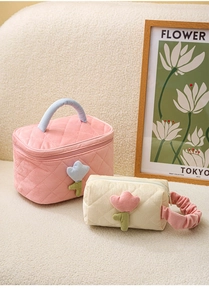 Detail of pink and white corduroy makeup bags with tulip accents and quilted texture