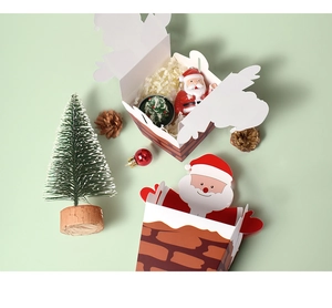 Detail of Santa Claus chimney gift box with paper shred filler and festive ornaments