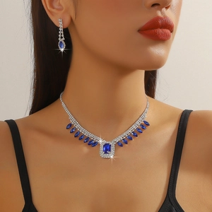 Close-up of elegant blue crystal necklace and teardrop earrings set on a female model