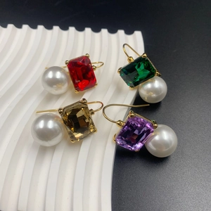 Macro shot of vintage style earrings with colorful gemstones and large white pearls