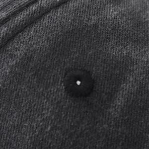Detailed macro view of high-quality breathable embroidered eyelet on charcoal cotton cap