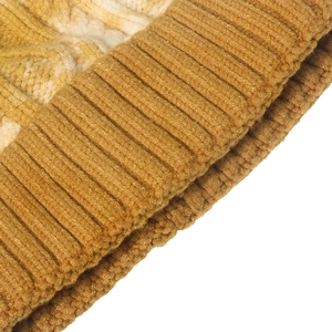 Close-up of thick cable knit texture and ribbed brim on yellow gradient beanie