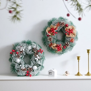 Pair of festive artificial Christmas wreaths with pine cones and red berries