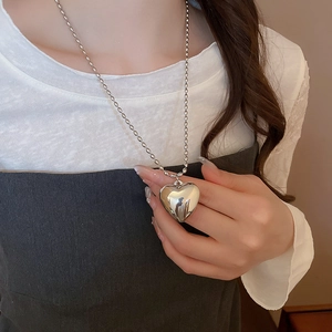 Close-up of a minimalist heart pendant necklace with polished silver bead chain