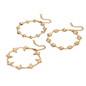 Golden stainless steel bracelet set featuring butterfly, heart and shell charms on white background
