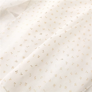 Close-up of white semi-transparent scarf fabric with delicate gold floral patterns