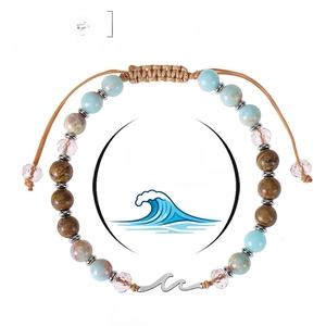 Verstellbares 6mm Naturstein-Wellenarmband mit blauen Kristallperlen auf weißem Grund