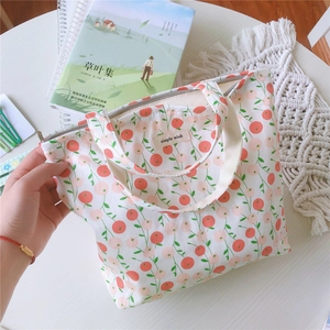 Détail d'un sac en coton à motif cerises avec fermeture éclair et étiquette interne