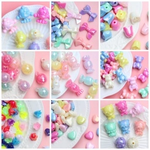 Macro display of colorful acrylic DIY beads in heart, flower, and bear shapes