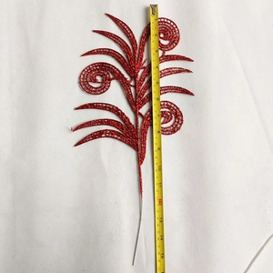 Detailed size measurement of a 38cm red glitter Christmas decorative leaf with a tape measure
