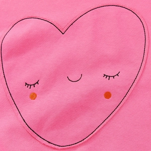 Dettaglio di una felpa rosa da bambina con una grande toppa a cuore ricamata