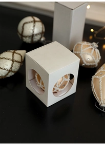 Detailed view of luxury Christmas ball with pearls and an elegant white gift box