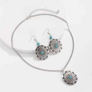 Detail of vintage bohemian silver jewelry set with turquoise beads on stone display stand