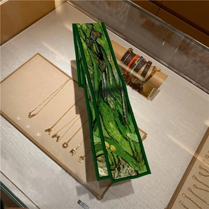 Detail of oil painting style silk scarf featuring artistic green iris flower patterns