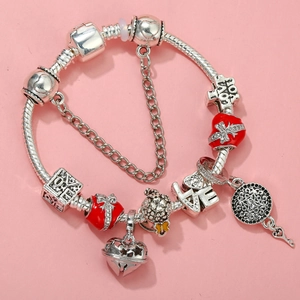 Detail of silver-plated charm bracelet with red enamel heart and LOVE letter charms