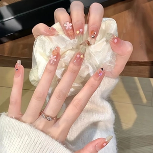 Long trapezoidal press-on nails with pink tulip art, 3D floral accents, and glitter rhinestones