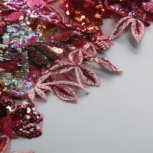 Detail of burgundy lace fabric with floral embroidery and sequins for elegant dresses