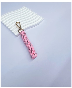 Detailed view of pink hand-woven nylon keychain with premium gold metal hook clasp