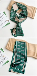 Detail of silk narrow scarf featuring horse print and houndstooth pattern on a tray