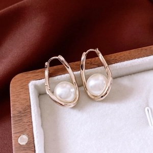 Detail shot of French style gold twisted earrings with elegant white pearls in jewelry box