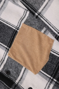 Detail of plaid shirt featuring a contrast corduroy pocket and black button sewing