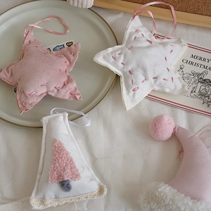 Pink and white fabric Christmas star ornaments with lace details and soft embroidery
