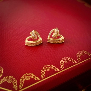 Macro detail of hollow heart earrings with cubic zirconia on a luxury jewelry box